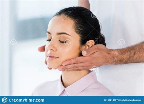 view of masseur holding hands near neck of attractive woman stock image image of neck partial
