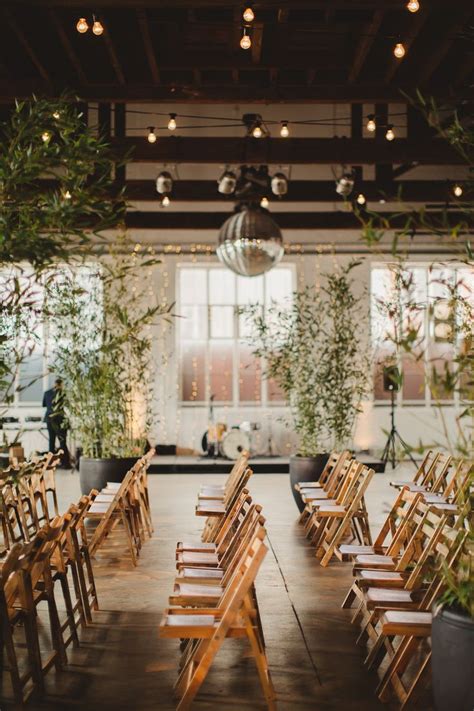 Rows Of Wooden Chairs Lined Up In An Indoor Venue With Plants Growing