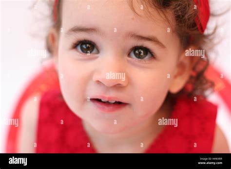 Close Up Of A Sweet Baby Girl Child Kid Toddler With Curly Hair And