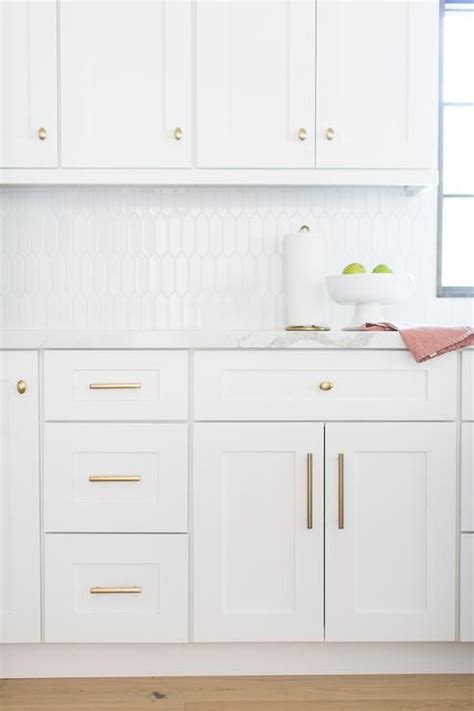 Looking only at the base cabinets: Brass cabinet hardware accent white shaker cabinets finished with white quartz countertops and ...
