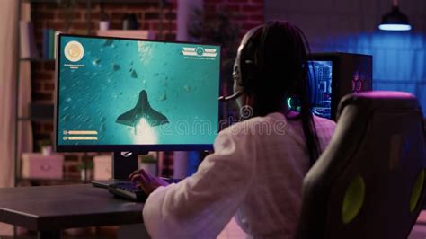 Over Shoulder View Of African American Gamer Girl Playing Space Shooter