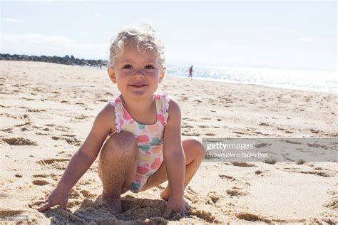 Little Girl Playing With Sand On Beach High Res Stock Photo Getty Images