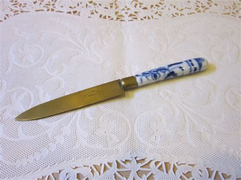 A Blue And White Knife Sitting On Top Of A Doily Covered Table Cloth