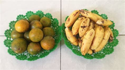 Two Bunch Ripe Bananas And Oranges Fruit On A Green Plastic Plate In