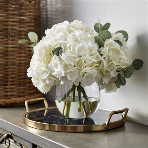 large white hydrangea and eucalyptus arrangement in rounded glass vase