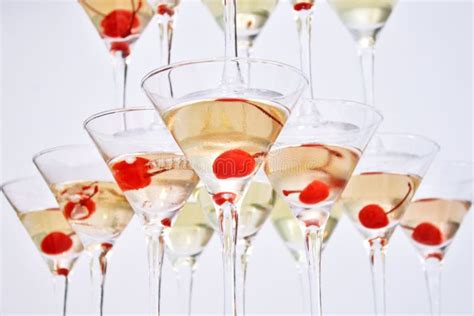 Triangular Martini Glasses Filled With Champagne With Cherries Built In The Shape Of A Pyramid
