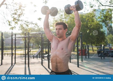 Muscular Male Athlete With Arms Raised Doing Lifting Exercises