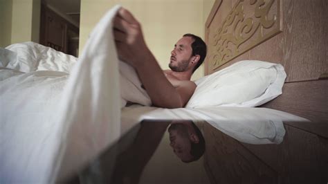 Premium Stock Video Waking Up Angrily To Morning Alarm Naked In Luxurious Hotel Bed
