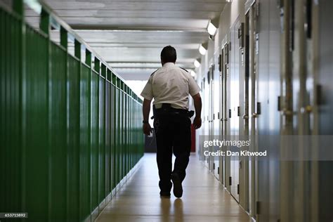 A Prison Guard Walks Through A Cell Area At Hmp Berwyn On March 15