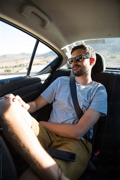 Young Man Traveling On The Back Of A Car On A Road Trip At Sunset By Stocksy Contributor