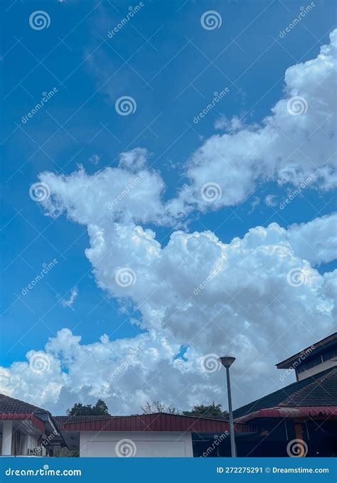 Fluffy White Clouds In The Blue Sky Over The Buildings Stock Image