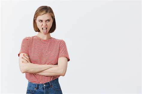 Free Photo Disgusted Young Grimacing Woman Showing Tongue And