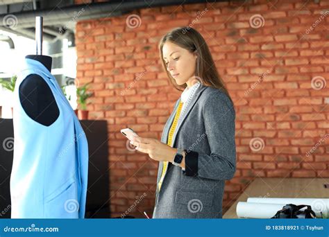 Thoughtful Young Beautiful Woman Is Holding Smart Phone While Standing