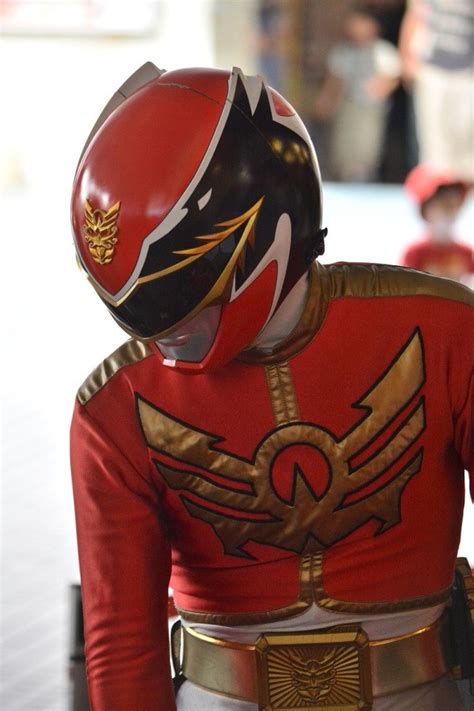 A Person Wearing A Red And Gold Uniform With Wings On Its Chest