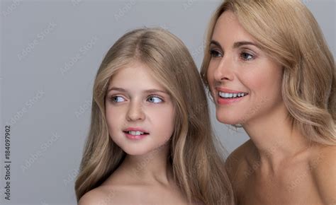 Joyful Attractive Mother And Her Adorable Little Daughter Are Standing
