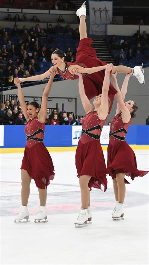 Three Female Figure Skaters Performing On An Ice Rink