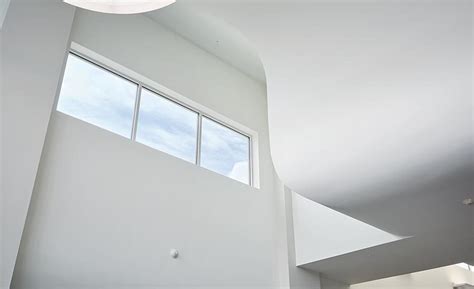 Curved Drywall Soffits Bounce Natural Light Into Student Center Walls