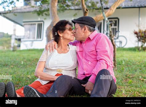 Cute Old Couple Sitting In A Garden Full Of Nature And Trees Giving