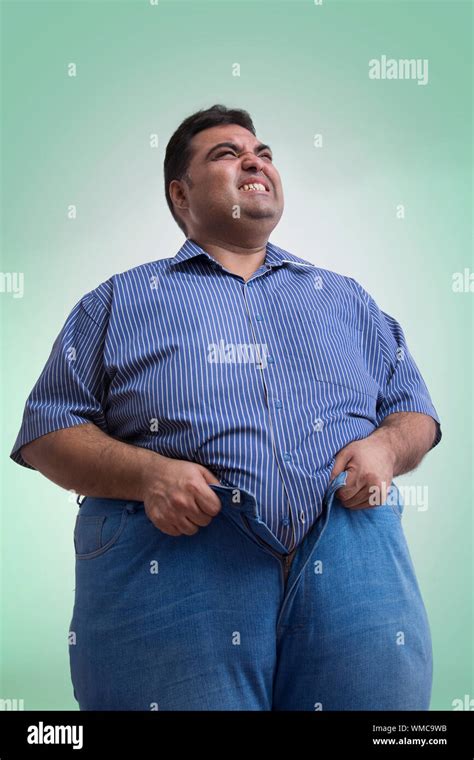 Unhappy Obese Man Trying Hard To Wear His Pants Not Fitting His Waist