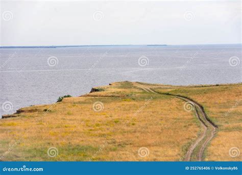 Dirt Road Leading To The Edge Of A Cliff Above The Water Stock Photo