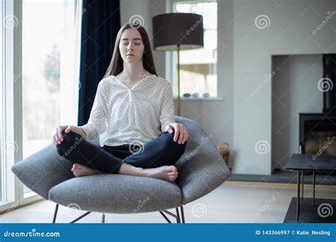Peaceful Teenage Girl Meditating Sitting In Chair At Home Stock Image