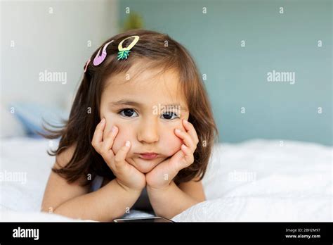 Portrait Of Bored Little Girl Lying On Bed Stock Photo Alamy