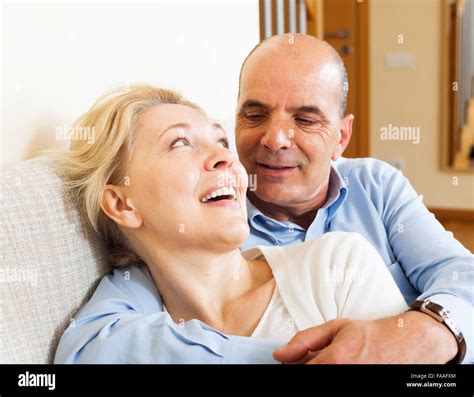 Happy Mature Woman Smiling And Hug With Husband In Home Interior Stock