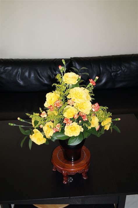 Triangle arrangement with yellow colour roses and spray carnations. | Flower arrangements ...