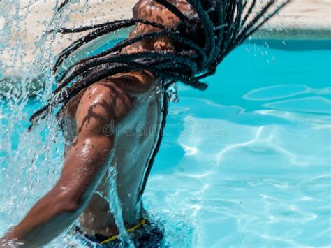 Black Man With Afro Hair And Dreadlocks Comes Out Of The Pool Splashing