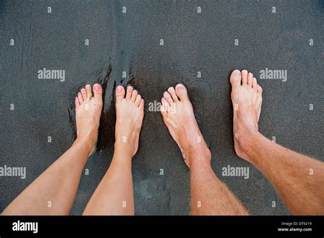 Pairs Of Male And Female Feet On Black Sand Stock Photo Alamy