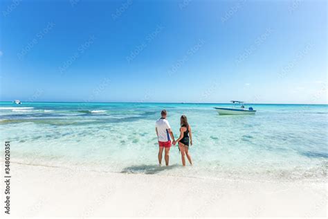 romantic couple in love hugging kissing and running on the sandy tropical caribbean beach in