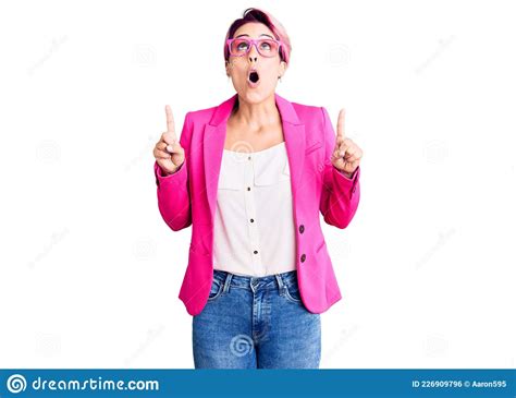Young Beautiful Woman With Pink Hair Wearing Business Jacket And Glasses Amazed And Surprised