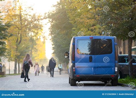 Passenger Van Car Parked On A City Alley Street Side With Blurred