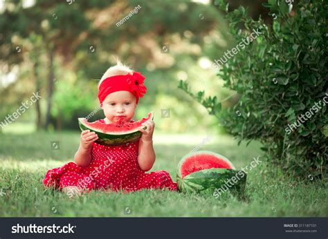 Cute Baby Girl Eating Watermelon Outdoors Looking At
