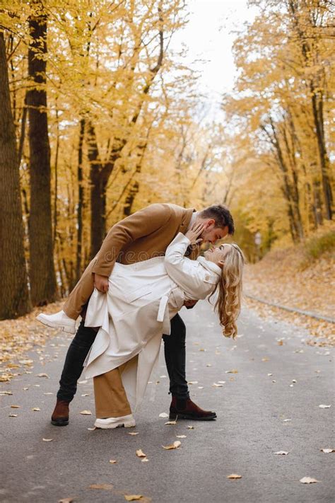 Romantic Couple Walking In Autumn Forest And Kissing Stock Photo
