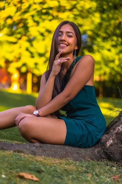 Premium Photo A Young Pretty Latina Brunette With Long Straight Hair Leaning Against A Tree