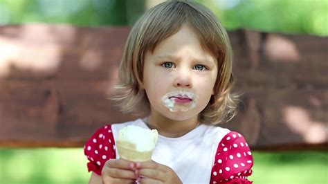 Beautiful Girlie Sits On The Bench Eats Ice Cream And Licks Her Lips Stock Video Footage