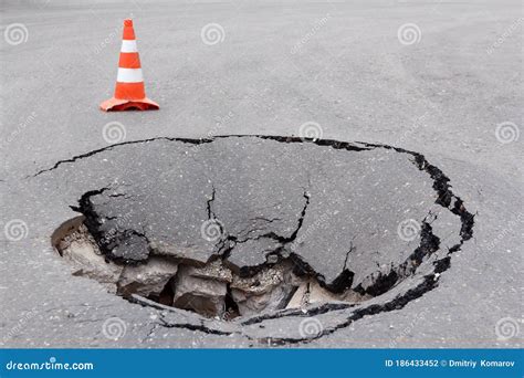 Deep Sinkhole On Street City And Orange Traffic Cone Dangerous Hole In