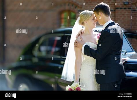 Bride and groom posing by a vintage car Stock Photo - Alamy