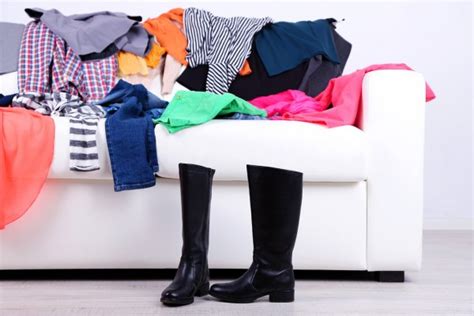 Messy Colorful Clothing On White Sofa On White Wall Background Stock