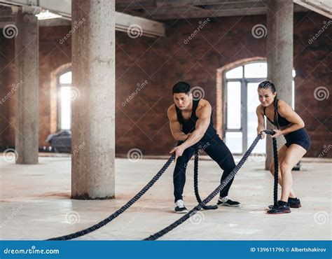 Motivated Couple Working Out With Battle Ropes Stock Photo Image Of