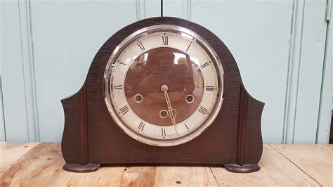 An Old Clock Sitting On Top Of A Wooden Table