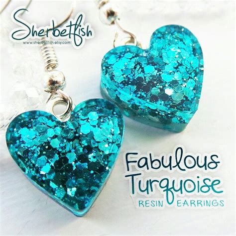 Two Heart Shaped Earrings With Blue Glitter On Them