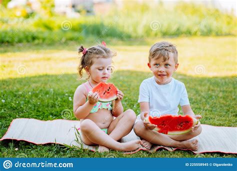 Two Kids Eat Watermelon In The Garden Kids Eat Fruit Outdoors Healthy