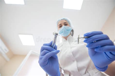 Attractive Smiling Woman Doctor In A White Uniform With Tools In Hand