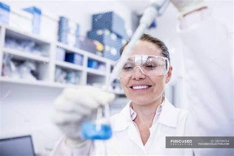 Female Laboratory Assistant Using Pipette — Caucasian Safety Stock