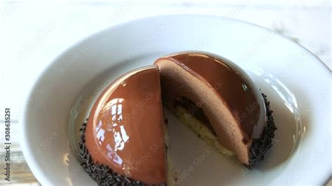 Shiny Mirror Glaze Mousse Dome Brown Glazed Cake Cut In Two Halves Modern French Pastry Stock