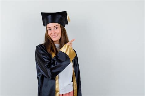 Free Photo | Female graduate pointing at upper right corner in academic ...