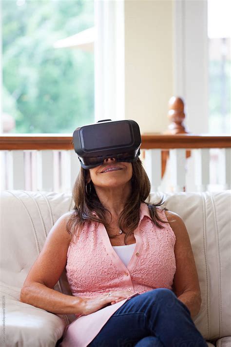 Vr Mature Woman Sits Back To Enjoy Virtual Reality Headset By Stocksy Contributor Sean Locke