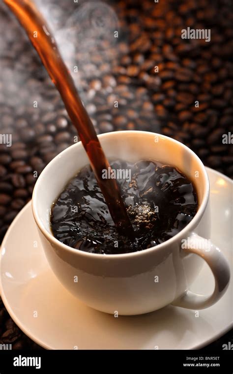 Pouring A Cup Of Traditional Steaming Hot Coffee Against Coffee Bean